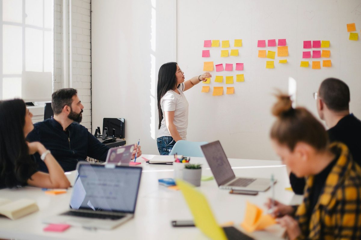 Team collaborating around a whiteboard in a project planning session. Photo: Unsplash.