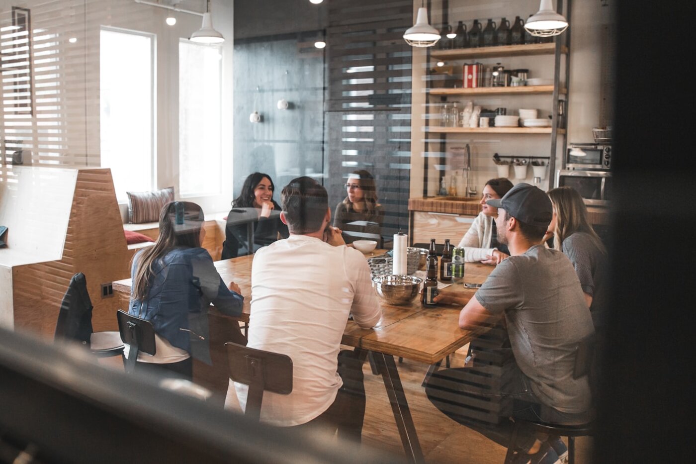 Cross-functional team around a conference table reviewing product changes—the human Change Control Board Arena’s ECO routing is meant to accelerate. Photo: Unsplash.