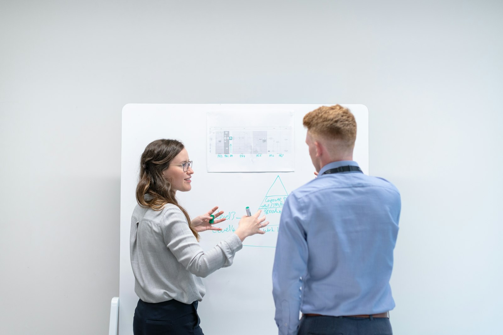 Engineers collaborating at a whiteboard on a technical process—assembly and feature-intent decisions AutoAssemble and AutoTimeline aim to recover from dead CAD. Photo: Unsplash.