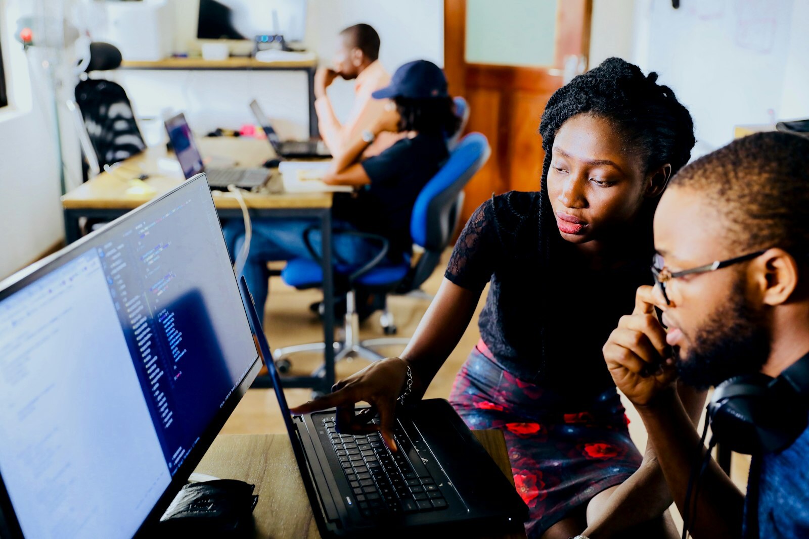 Engineers reviewing software at a workstation—the CAD/CAM/PLM handoff Autodesk wants AutoTimeline, System Modeler, and agentic PLM to compress. Photo: Unsplash.