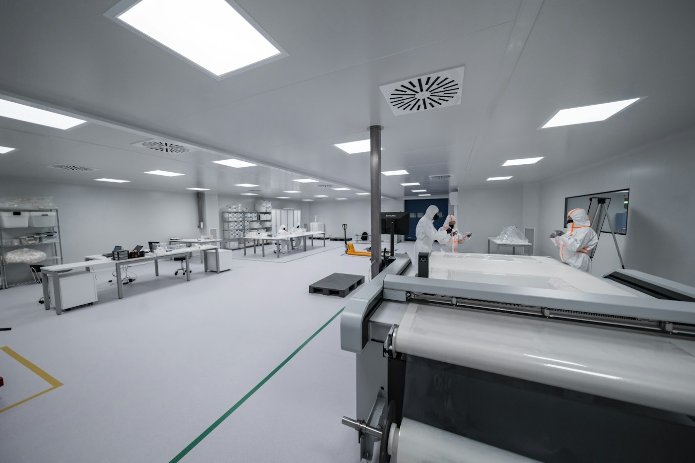 Cleanroom operators at controlled workstations—where MES job history and automation events must stay auditable. Photo: Unsplash.