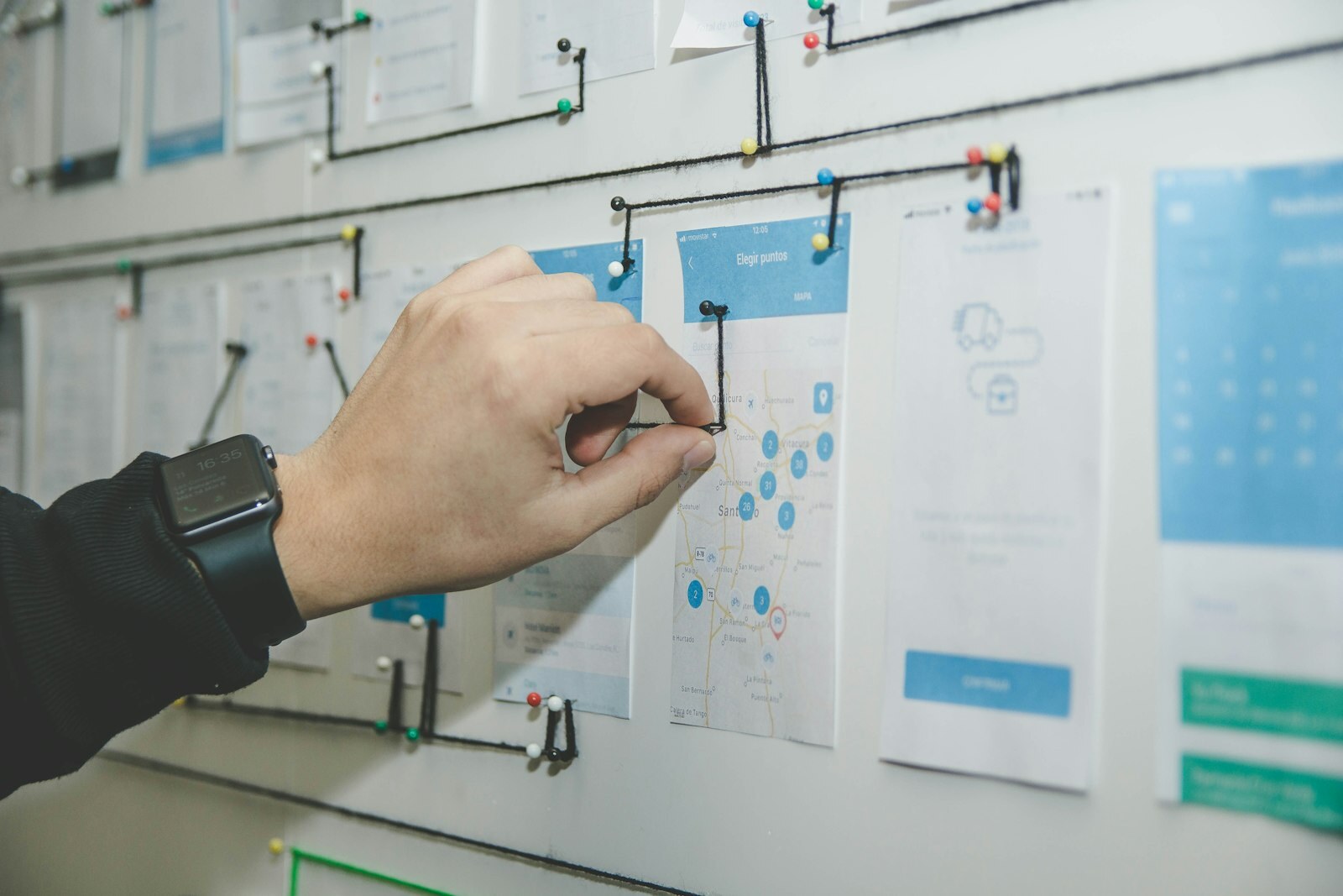 Team mapping software workflow diagrams and sticky notes on a wall during project planning