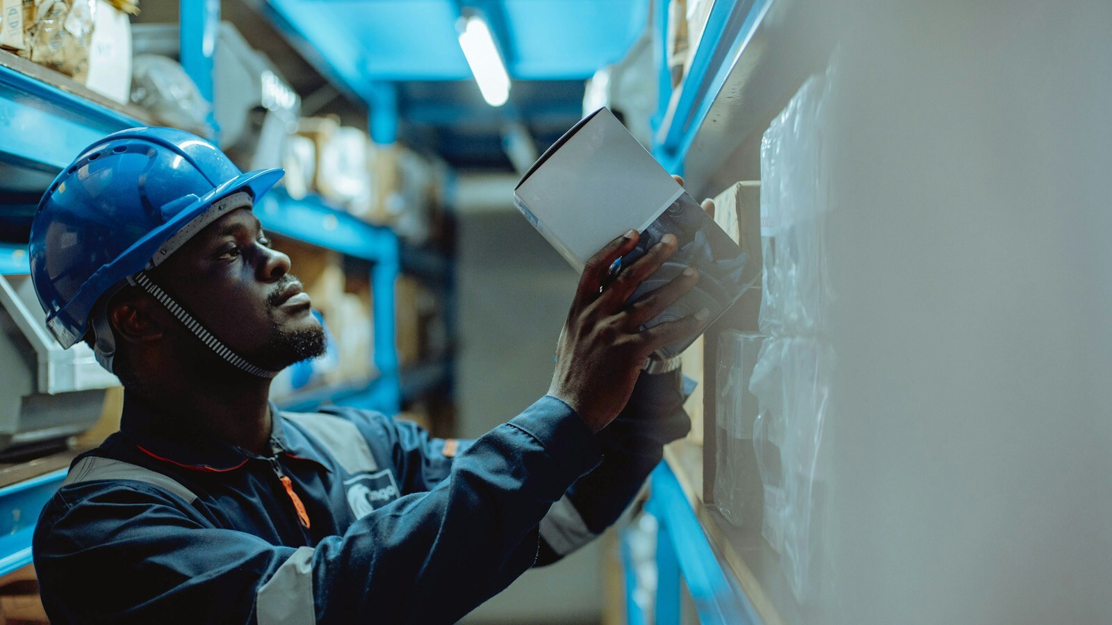 Factory worker in a hard hat reviewing a paper checklist on the shop floor