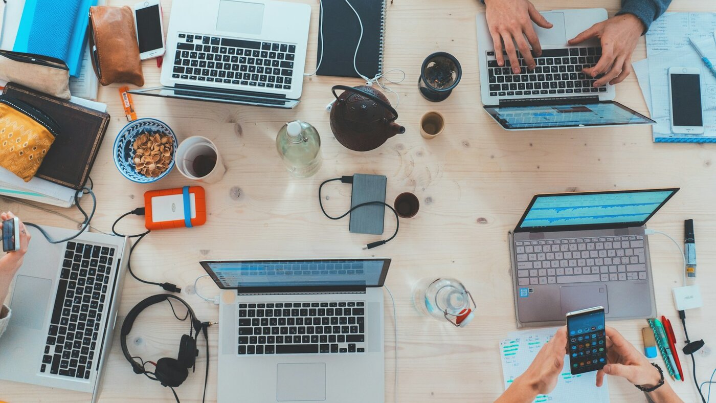 Team collaborating around laptops and tablets in a modern office
