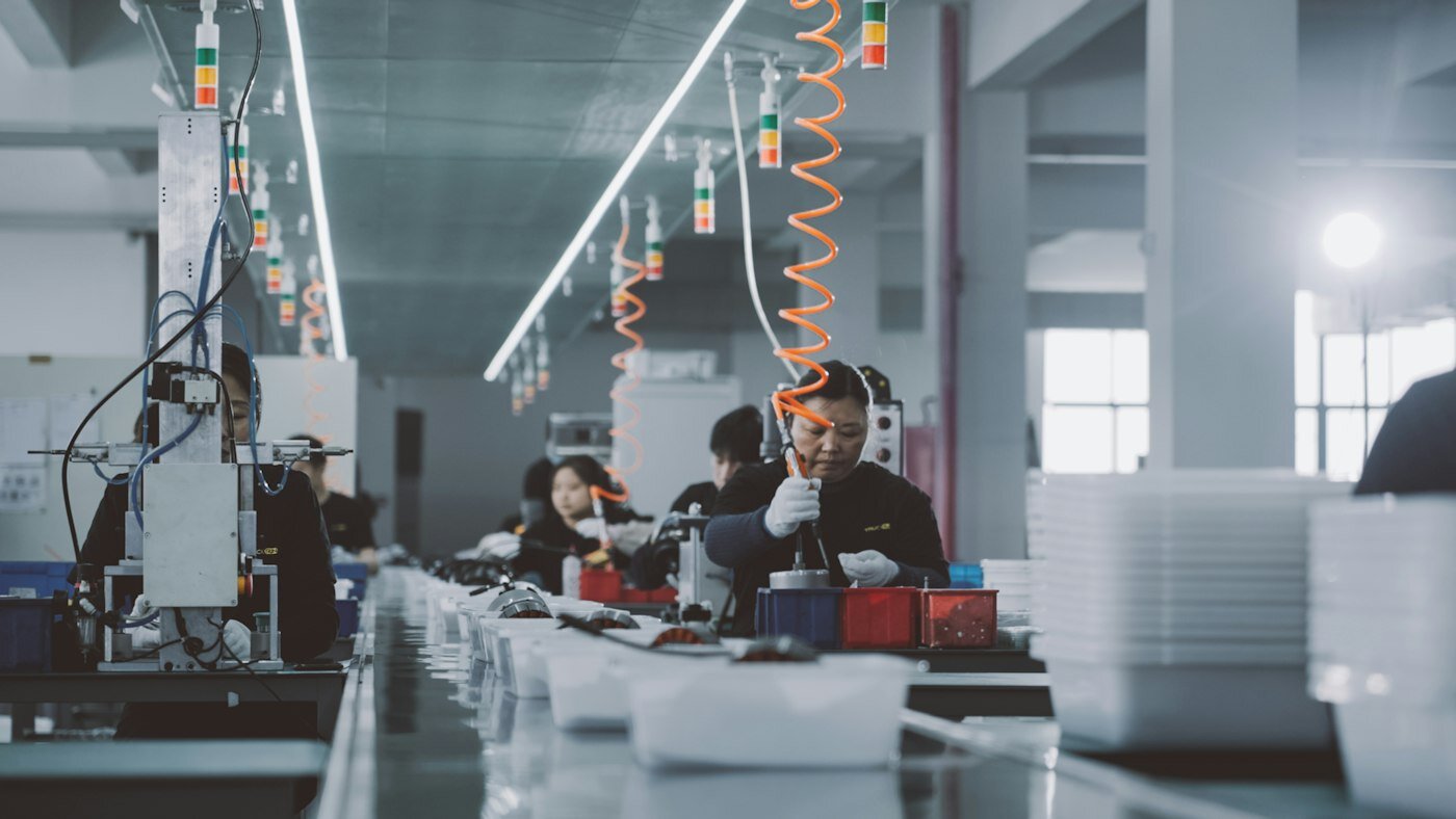 Factory workers collaborating on an assembly line inside an industrial plant