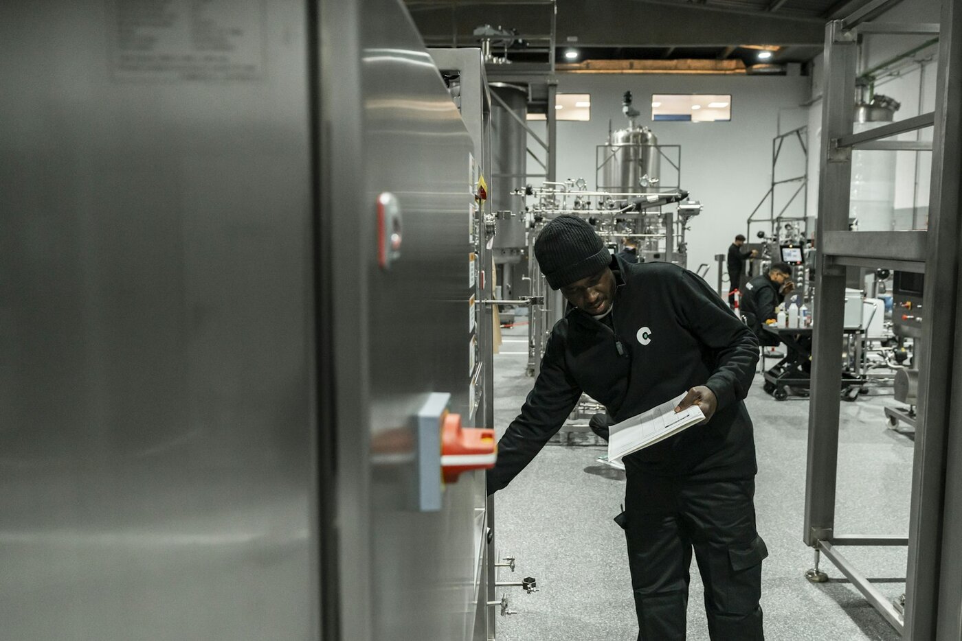 Engineer inspecting equipment on a modern factory floor