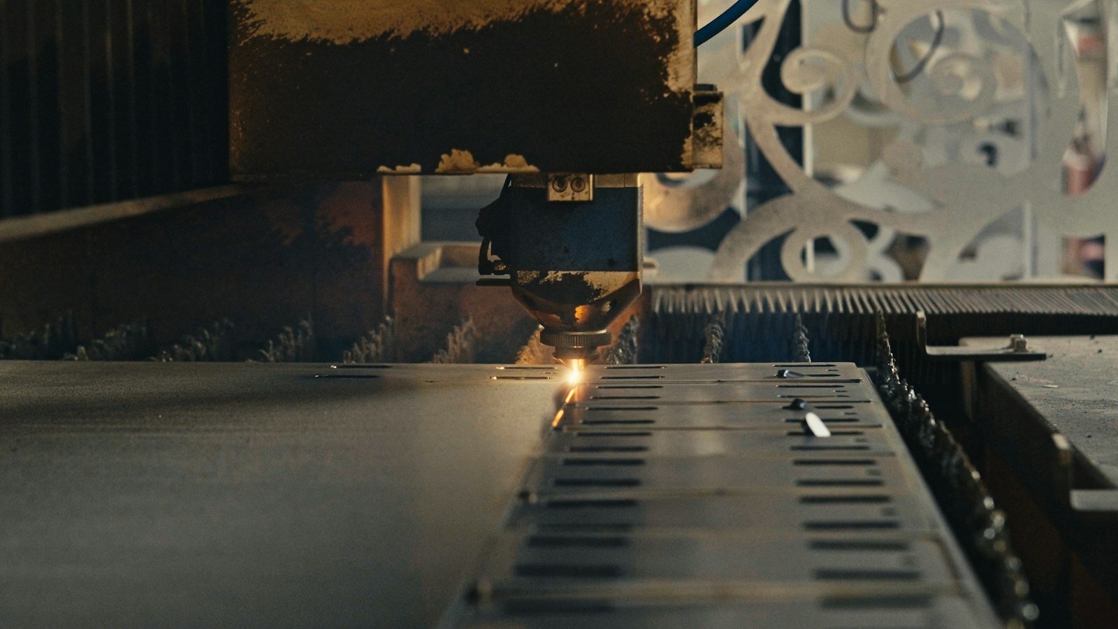 Laser cutting machine engraving sheet metal in a fabrication shop—where Fusion’s new Join by Bend and sheet-metal edge tools meet the floor. Photo: Unsplash.