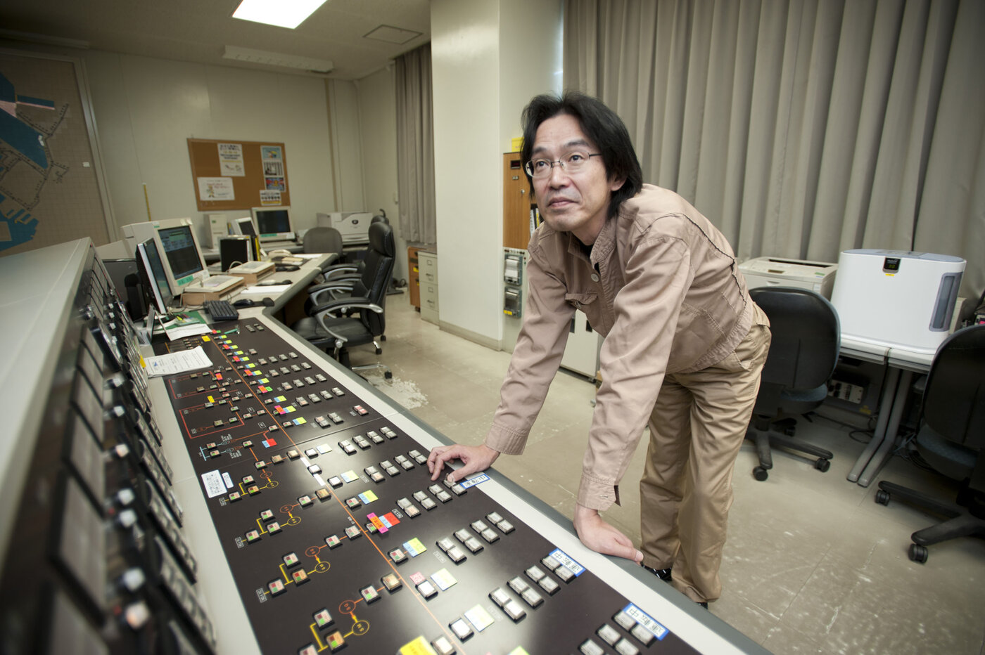 Operator at a supervisory control and data acquisition (SCADA) console balancing electrical load on industrial displays. Photo: U.S. Navy via Wikimedia Commons.