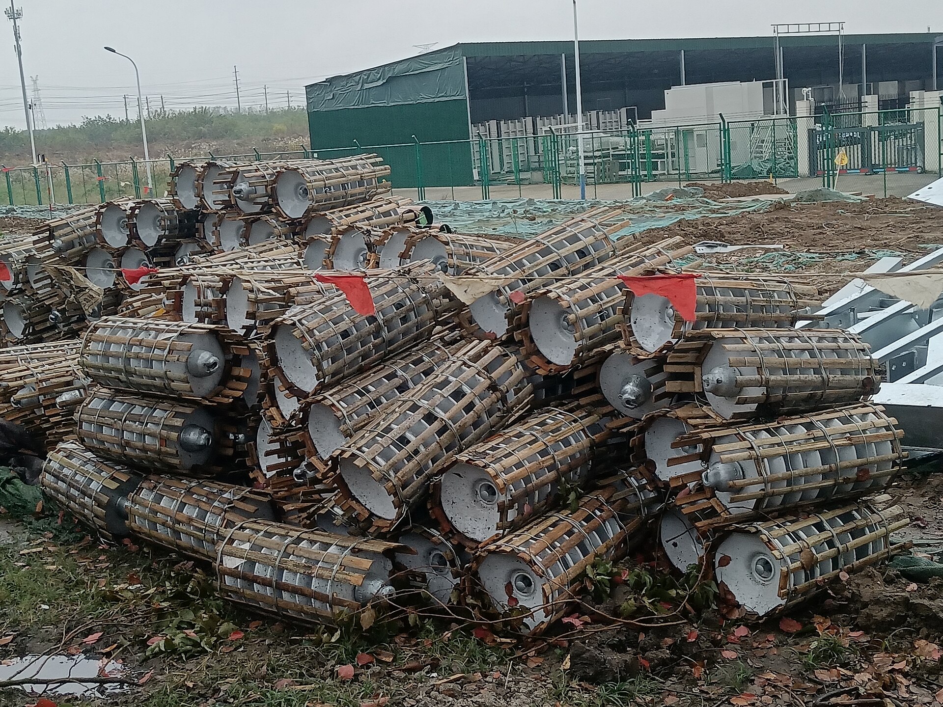 Coils of heavy steel conveyor chain stacked outside an industrial building.