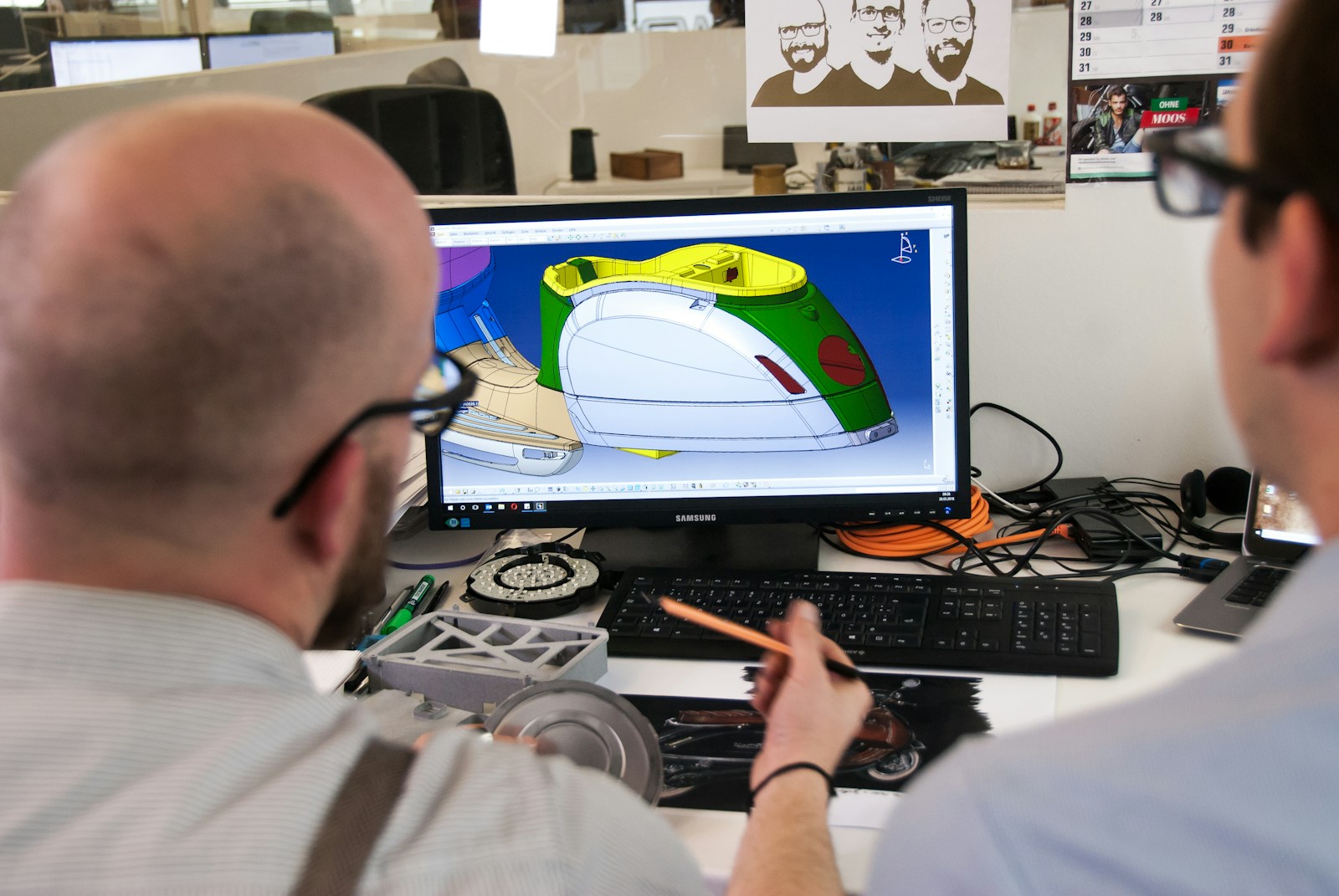 Engineer using a CAD tool to design an electric scooter on screen.
