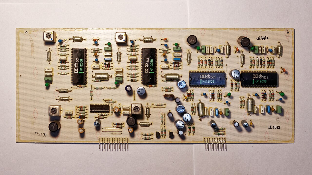A populated printed circuit board with integrated circuits, capacitors and resistors, seen from above.