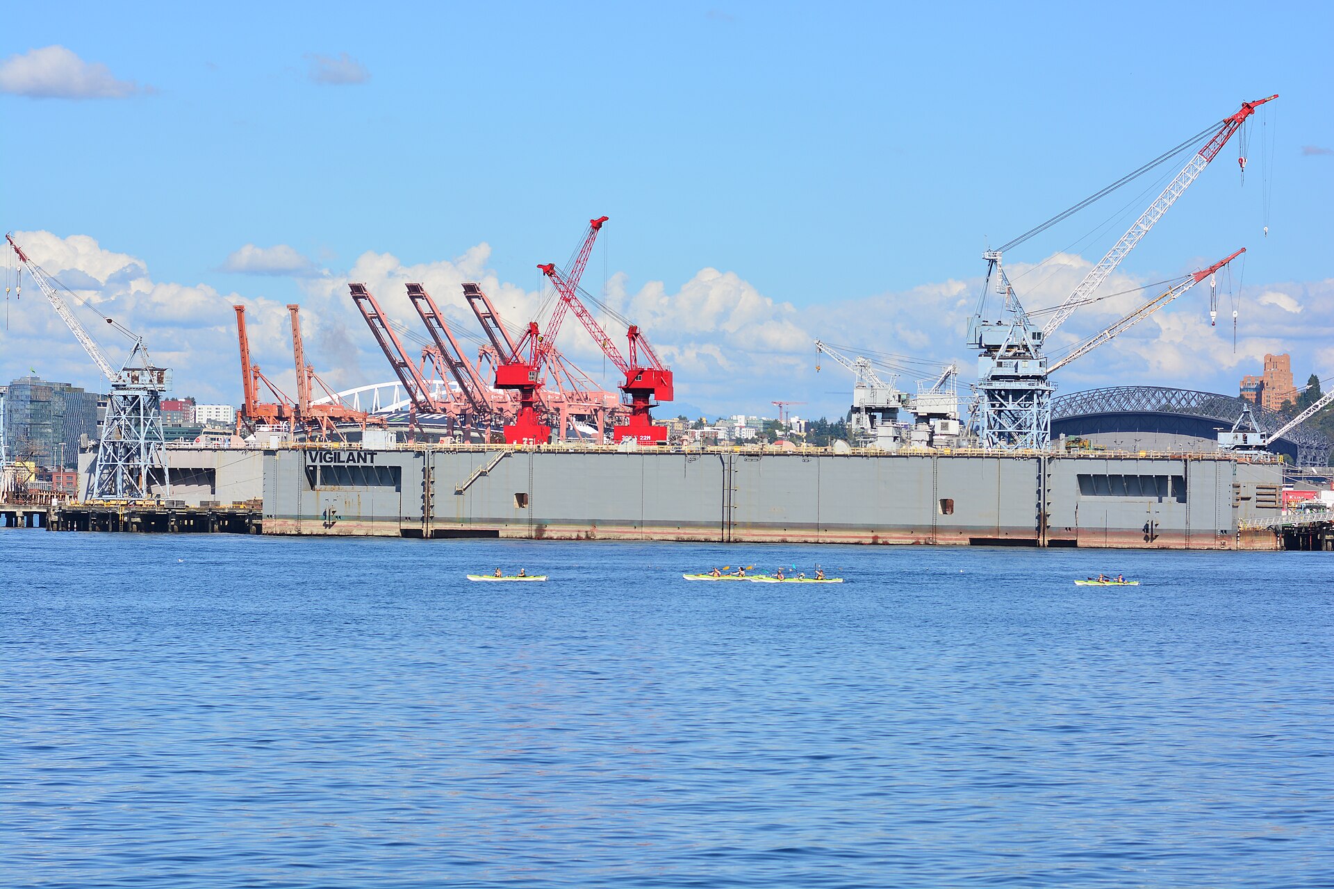 Floating drydock and red shipyard cranes at Vigor Shipyard on Harbor Island, Seattle, seen across Elliott Bay.