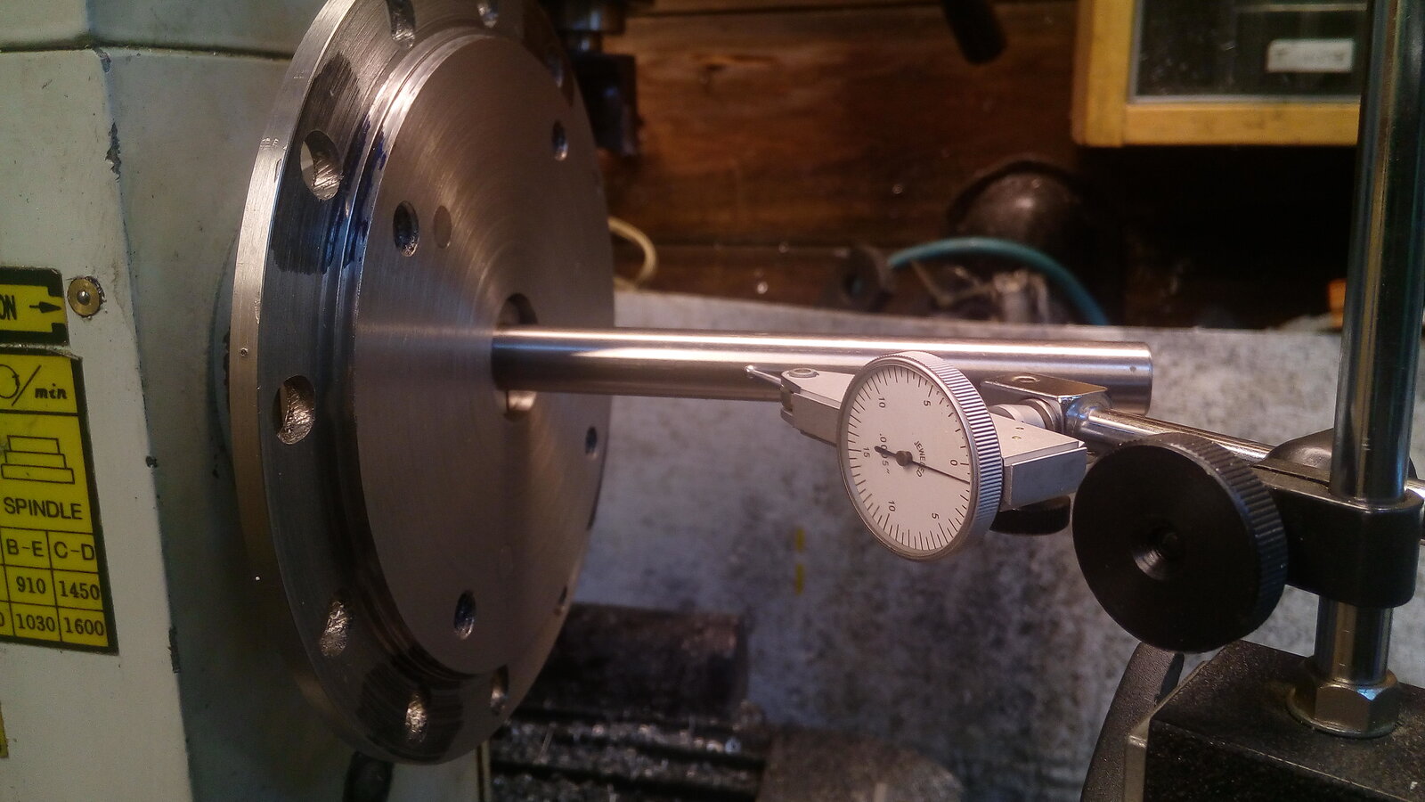Dial test indicator checking runout on a lathe cross-slide—shop-floor inspection that must feed CAPA and complaints. Photo: David English / Wikimedia Commons.